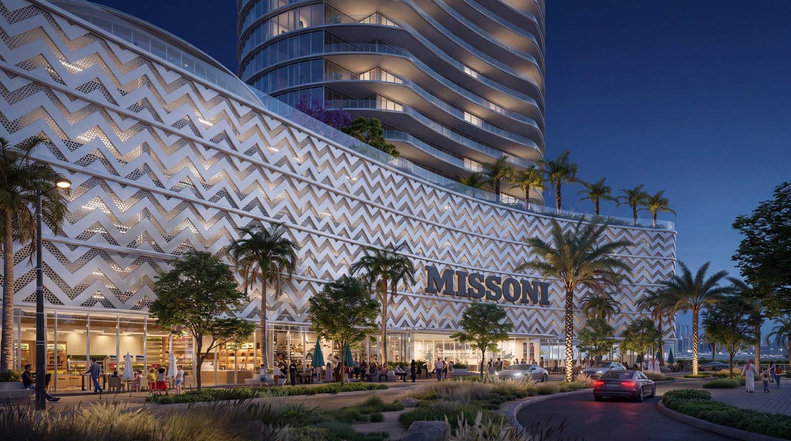 Waterfront by Missoni at night, the zigzag-patterned podium lit above a busy arrival drive and the curved tower rising behind