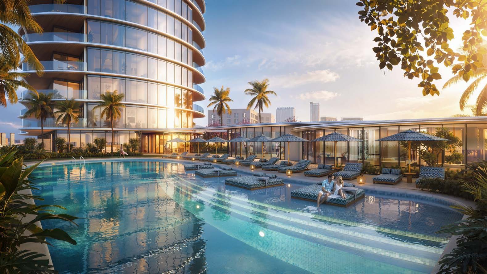 The outdoor swimming pool at Waterfront by Missoni at golden hour, with Missoni-patterned cabanas and the curved tower above